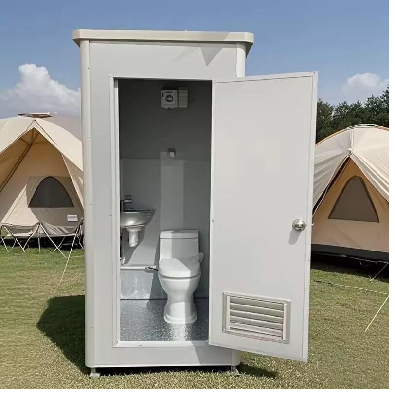Portable restrooms lit by string lights at an evening wedding