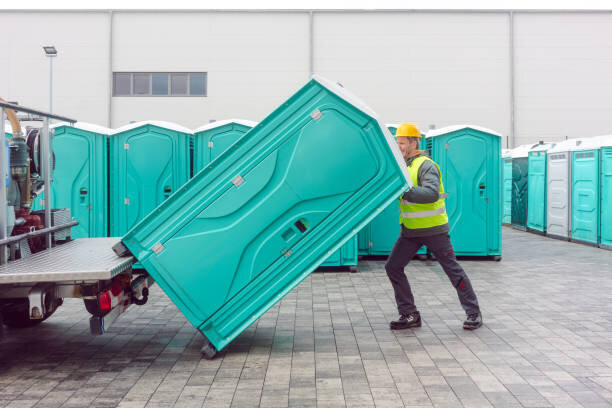 Crew member delivering a portable toilet unit to a construction site in El Cajon